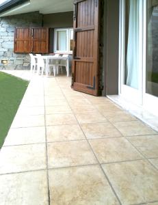 a patio with a wooden door and a table at Sa Tirìa in Chia
