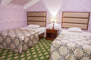 a bedroom with two beds and a table with a lamp at City Line Boutique Hotel in Tashkent