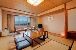 a living room with a table and chairs and a window at Kyukamura Ura-Bandai in Kitashiobara