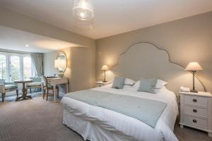 a bedroom with a large white bed and a desk at Heacham Manor Hotel in Hunstanton