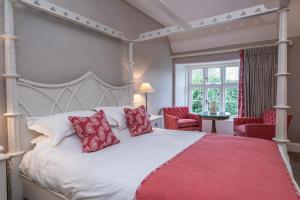 a bedroom with a large white bed with red pillows at Heacham Manor Hotel in Hunstanton