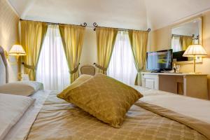 a bedroom with a large bed and a large window at Hotel La Locanda in Volterra