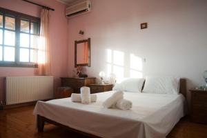 a bedroom with a white bed with towels on it at Ancient Olympia Luxury Pool Villa Palace 4Bedroom in Olympia