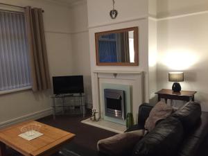 a living room with a couch and a fireplace at The Mules in Newbiggin-by-the-Sea