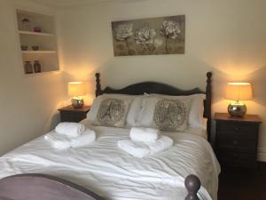 1 dormitorio con 1 cama con toallas en The Mules, en Newbiggin-by-the-Sea