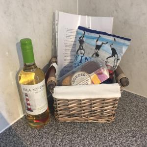 a bottle of wine and a basket with a bottle of wine at The Mules in Newbiggin-by-the-Sea