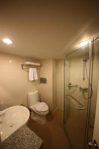 a bathroom with a toilet and a shower and a sink at Sunshine Hotel & Residences in Pattaya