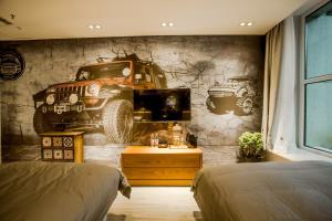 een slaapkamer met een muurschildering van een truck aan de muur bij Yamei Garden Homestay in Hohhot