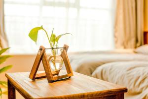 una mesa de madera con un jarrón encima en Yamei Garden Homestay, en Hohhot