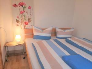 Schlafzimmer mit einem Bett mit blauen und weißen Kissen in der Unterkunft Stadtwohnung in Usedom Town