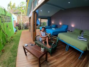 a woman sitting on a couch in a room with two beds at Blue Coco in Keramas