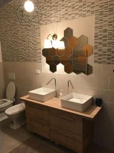 a bathroom with two sinks and a toilet at The Butcher-Ducati and Airport BLQ in Bologna