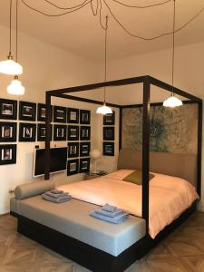 een slaapkamer met een hemelbed en 2 handdoeken bij The Butcher-Ducati and Airport BLQ in Bologna
