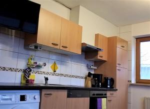 a kitchen with wooden cabinets and a counter top at Ferienwohnung-4you in Sigmarszell