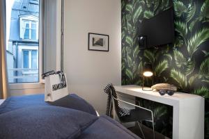 a bedroom with a bed and a tv on a wall at Hotel Brady - Gare de l'Est in Paris