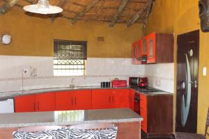 a kitchen with red cabinets and a counter top at Soul Village Farm Self Catering Retreat in Hekpoort