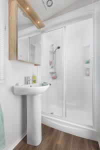 a bathroom with a sink and a shower at Polborder Holidays Looe Country Park in Looe