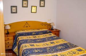 1 dormitorio con 1 cama con colcha azul y amarilla en Apartamento El Serrano, en Benaoján