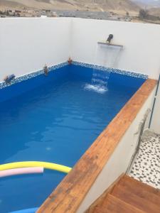 a pool with blue water and a wooden floor at Departamentos Playa San Bartolo in San Bartolo