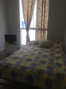 a bedroom with a bed and a window with curtains at Departamentos Playa San Bartolo in San Bartolo