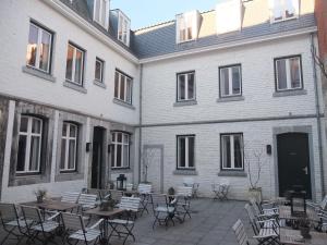 a courtyard with tables and chairs in front of a building at Boutique Hotel Grote Gracht in Maastricht