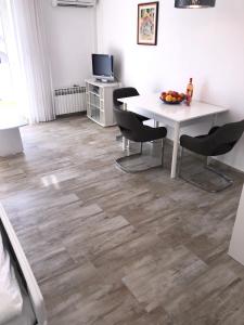 a dining room with a table and chairs and a television at Villa Jadro in Zadar