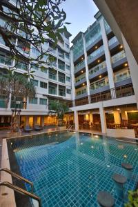 a swimming pool in front of a building at Sunshine Hotel & Residences in Pattaya