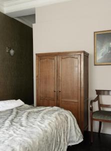 1 dormitorio con 1 cama y armario de madera en Boutique Hotel Grote Gracht, en Maastricht