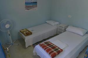 a room with two beds and a fan at Glamping Rooms at The Sea Turtle in Dhërmi