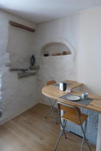 Zimmer mit einem Holztisch und Stühlen in einem Zimmer in der Unterkunft La maison du Plo in Fabrezan