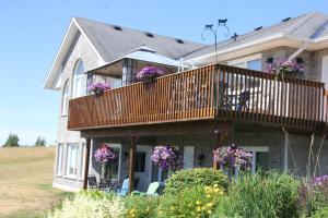 a house with a balcony with purple flowers on it at Golden Pathways Retreat B&B in Peterborough