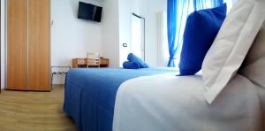 a bedroom with a bed with blue pillows on it at Hotel Mare Blu -- boutique in Pineto