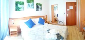 a bedroom with a large white bed with blue pillows at Hotel Mare Blu -- boutique in Pineto
