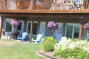 a deck on a house with chairs and flowers at Golden Pathways Retreat B&B in Peterborough