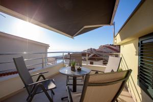 a balcony with a table and chairs on a balcony at Villa Podgorka in Podgora