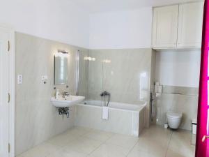 a bathroom with a sink and a tub and a toilet at Royal Road Residence II in Prague +17 photos
