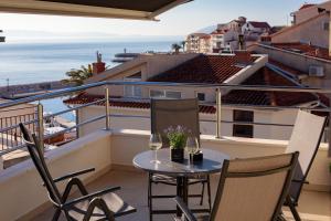 a balcony with a table and two glasses of wine at Villa Podgorka in Podgora