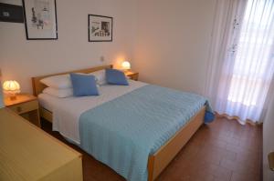 a bedroom with a large bed with blue pillows at Appartamenti Atlante in Bibione