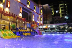 a swimming pool with a water park at night at Hotel Castillo Resort in San Gil