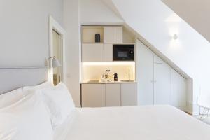 a white kitchen with white cabinets and white appliances at Boutique Chiado Suites in Lisbon