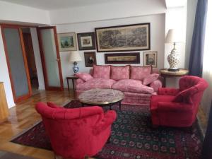 
a living room filled with furniture and a red couch at Plaza Huelen in Santiago
