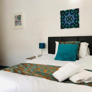 a bedroom with a white bed with a blue pillow at Opal Bank in Crewe