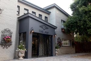 a building with a black entrance to a wine shop at Villa Petit in Jeffreys Bay