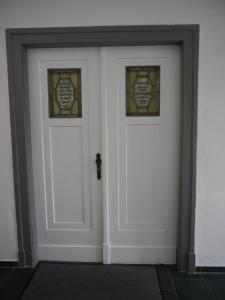 two doors with stained glass on them in a room at Altes Weingut Weinhaus Rebstock in Winningen