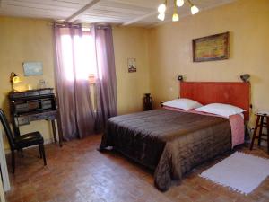 - une chambre avec un lit et un bureau dans l'établissement La Pierre Folle Chambres d'Hôtes, à Cluny
