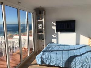 a bedroom with a bed and a balcony with a television at Espectacular apartamento cerca de Barcelona con free wifi in Canet de Mar