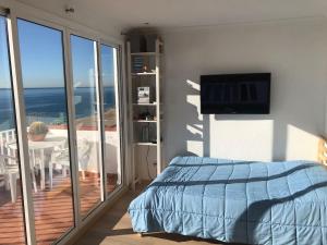 Schlafzimmer mit einem Bett und einem Balkon mit einem TV in der Unterkunft Espectacular apartamento cerca de Barcelona con free wifi in Canet de Mar