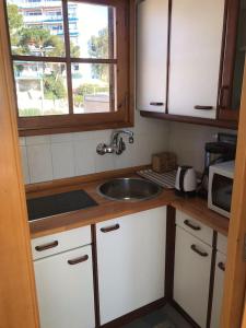 eine Küche mit Spüle und Mikrowelle in der Unterkunft Espectacular apartamento cerca de Barcelona con free wifi in Canet de Mar + 20 Fotos