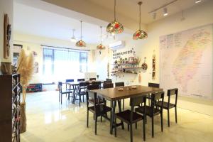 a dining room with tables and chairs and a map on the wall at 去那邊民宿-花蓮市電梯民宿 in Hualien City +53 photos