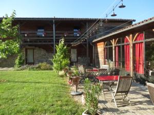 a patio with chairs and a table in a yard at La Pierre Folle Chambres d'Hôtes in Cluny